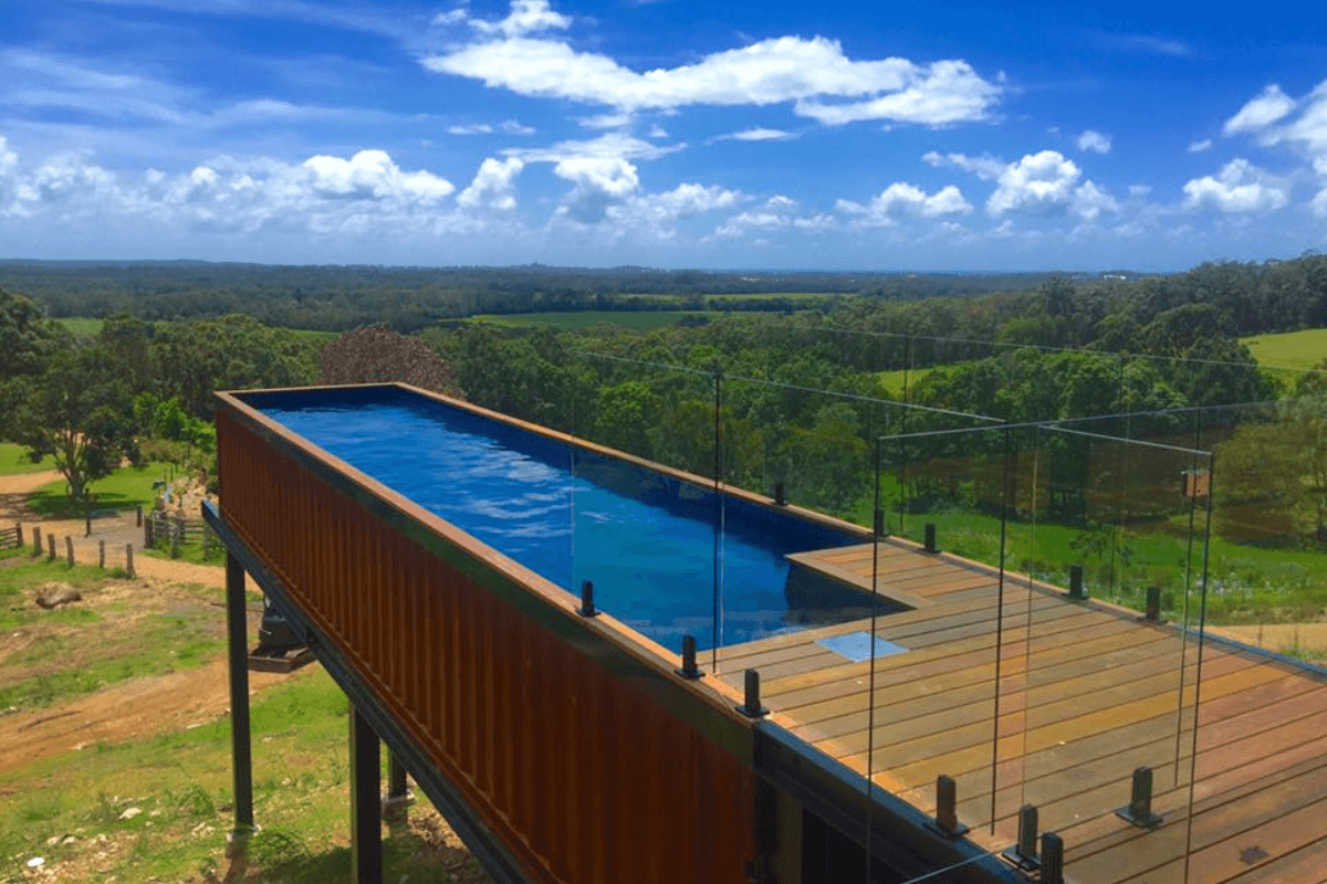 A shipping container pool built into side of a hillside